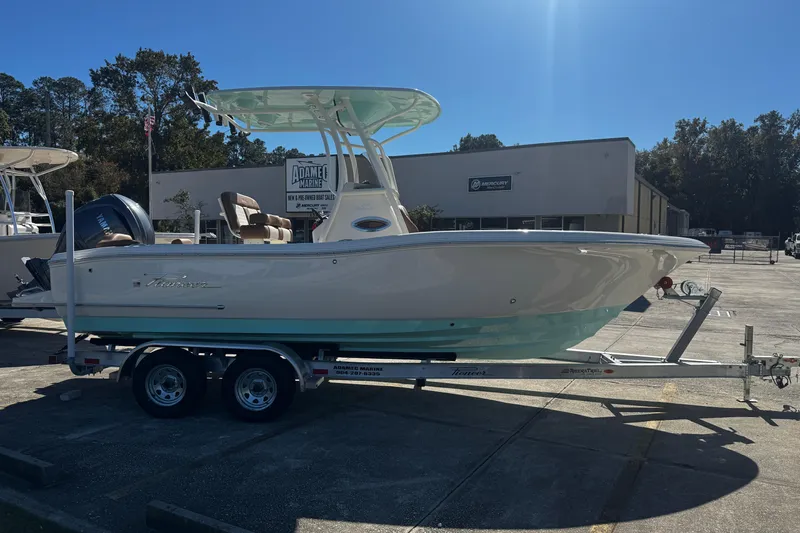 Slide: The Image of 2026 Pioneer 222 Islander boat on trailer, displayed outdoors at a marine dealership. - 2