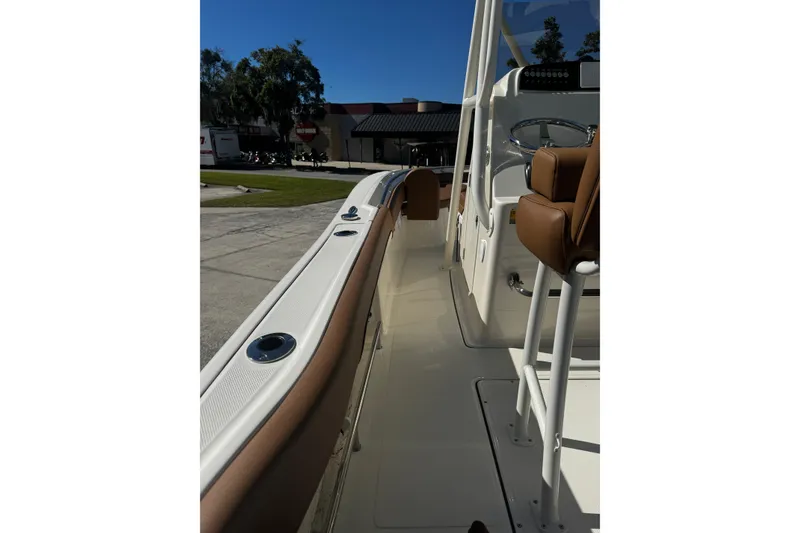 Slide: The Image of 2026 Pioneer 222 Islander boat interior with brown seating and sleek design. - 21
