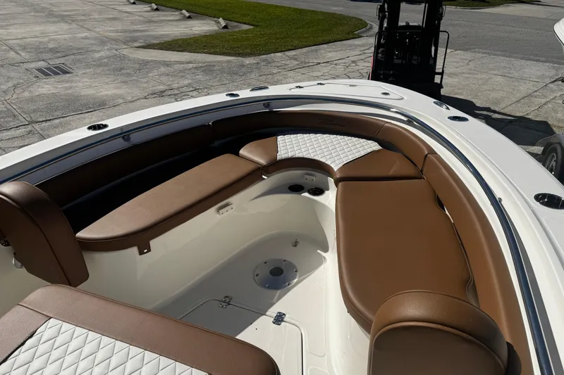 Slide: The Image of 2026 Pioneer 222 Islander boat interior with brown seating and white accents. - 25