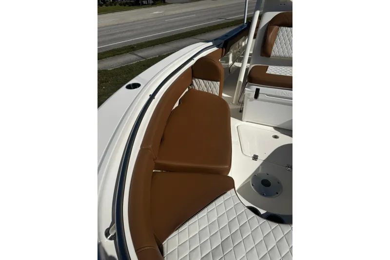 Slide: The Image of 2026 Pioneer 222 Islander boat with brown and white cushioned seating. - 30
