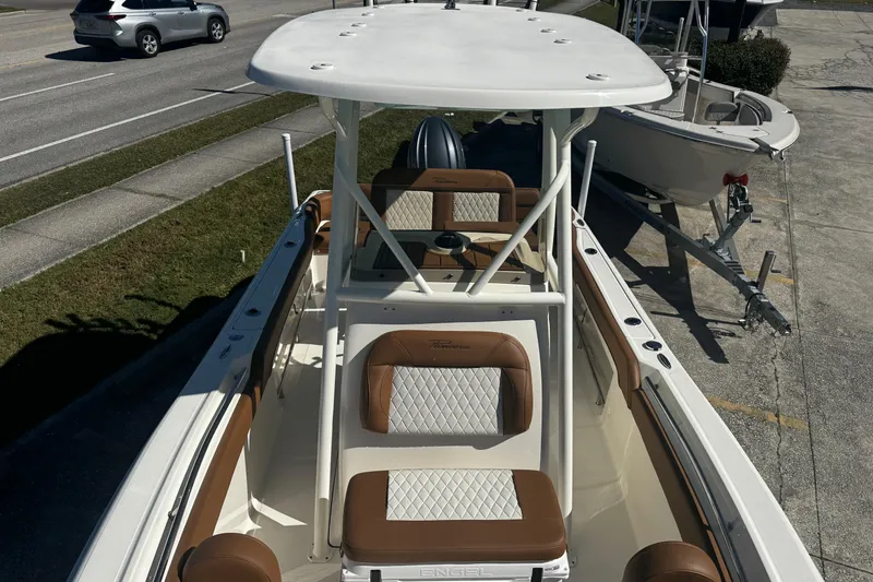 Slide: The Image of 2026 Pioneer 222 Islander boat with brown and white seating, parked on a trailer. - 32