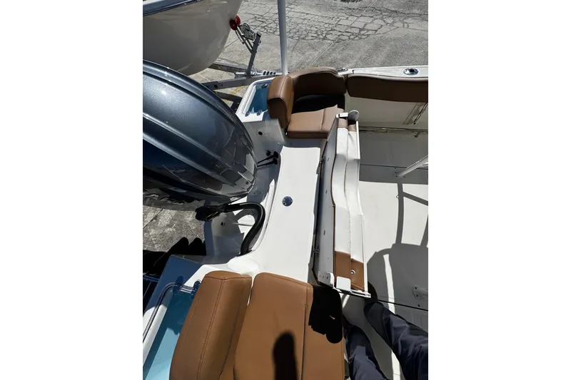 Slide: The Image of 2026 Pioneer 222 Islander boat interior with brown seating and engine view. - 37