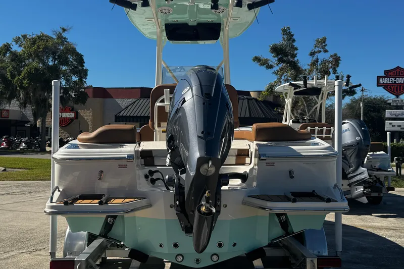 Slide: The Image of 2026 Pioneer 222 Islander boat with outboard motor, displayed outdoors on a sunny day. - 4