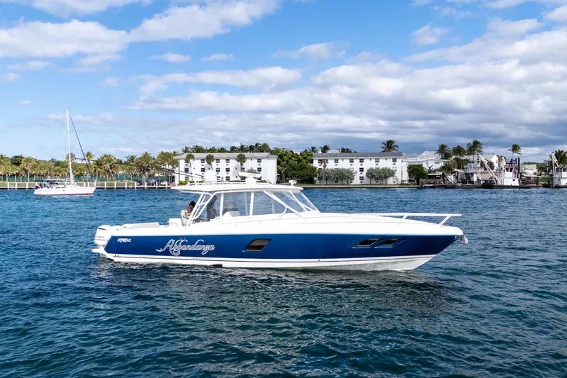 Slide: The Image of 2019 Intrepid 407 Cuddy boat on water, blue and white design, coastal background. - 13
