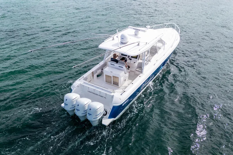 Slide: The Image of 2019 Intrepid 407 Cuddy cruising on open water, featuring triple outboard engines. - 15