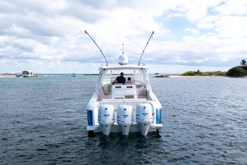 Slide: The Image of 2019 Intrepid 407 Cuddy boat on water, featuring triple outboard engines. - 17