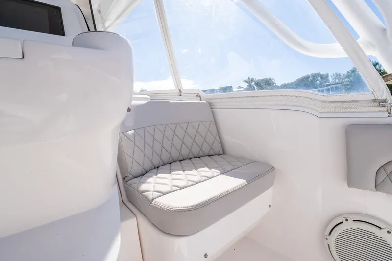 Slide: The Image of Interior of 2019 Intrepid 407 Cuddy boat with cushioned seating and window view. - 30