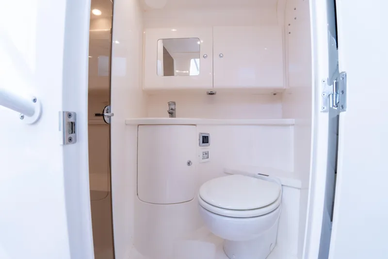 Slide: The Image of 2019 Intrepid 407 Cuddy boat bathroom with toilet and sink. - 39