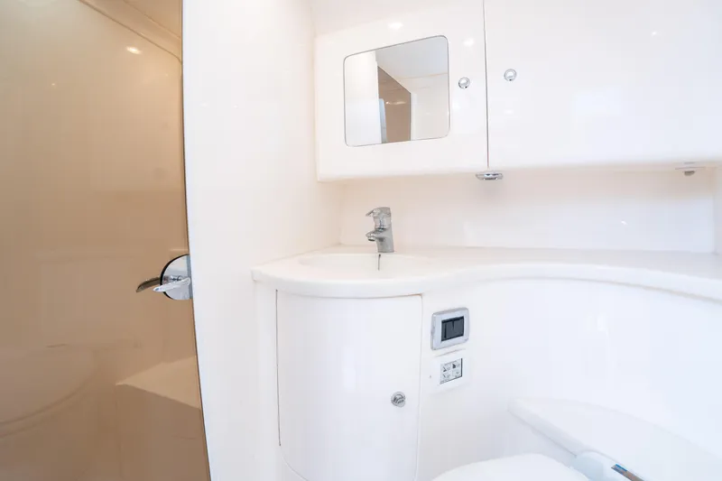 Slide: The Image of 2019 Intrepid 407 Cuddy boat bathroom with sleek white cabinetry and modern fixtures. - 40