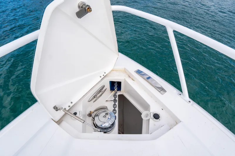 Slide: The Image of 2019 Intrepid 407 Cuddy anchor locker with open hatch, showing marine equipment. - 44