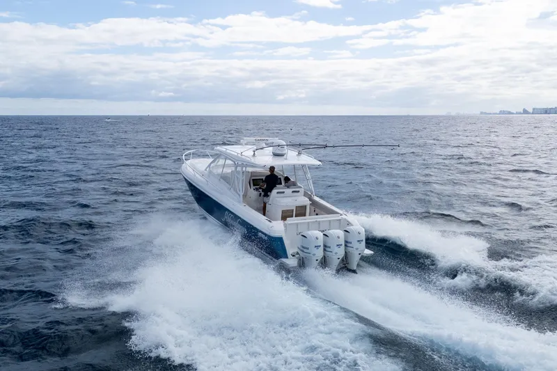Slide: The Image of 2019 Intrepid 407 Cuddy cruising on open ocean with triple outboard engines. - 5