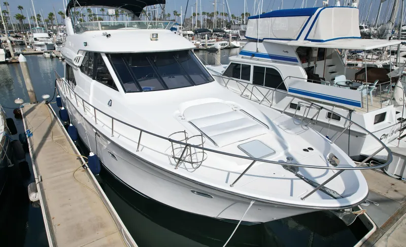 The Image of 1999 Bayliner 5288 yacht docked at marina, surrounded by other boats. - 0