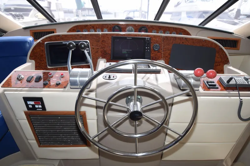 Slide: The Image of 1999 Bayliner 5288 yacht helm with steering wheel, controls, and navigation equipment. - 10