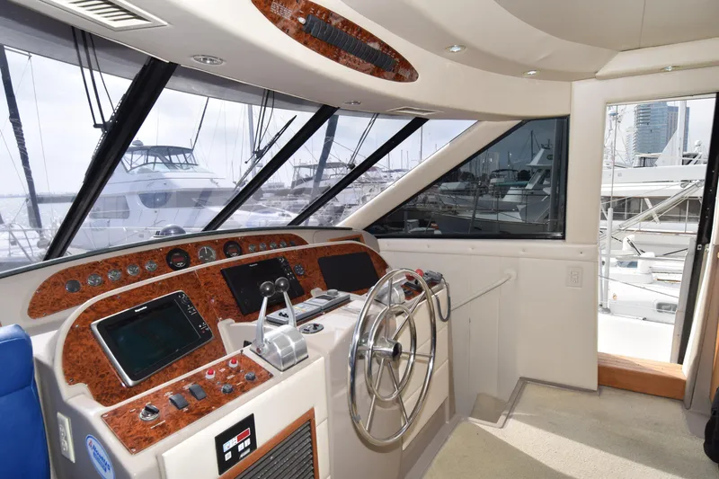 Slide: The Image of 1999 Bayliner 5288 yacht helm with modern controls and panoramic marina view. - 11