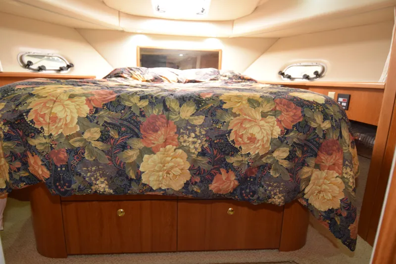 Slide: The Image of Luxurious cabin interior of 1999 Bayliner 5288 with floral bedding and wooden storage. - 16