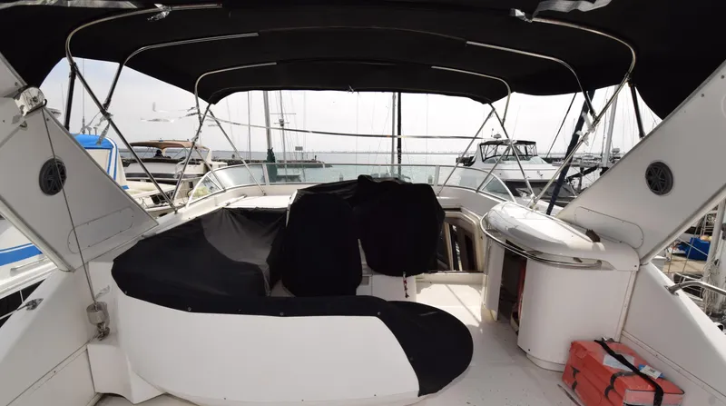Slide: The Image of 1999 Bayliner 5288 yacht interior with covered seating and canopy at a marina. - 19