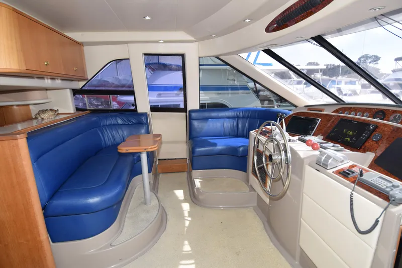 Slide: The Image of Interior of 1999 Bayliner 5288 yacht with blue seating and modern helm. - 2