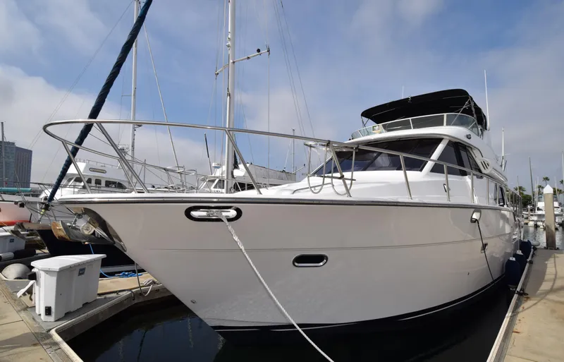 Slide: The Image of 1999 Bayliner 5288 yacht docked at marina under clear sky. - 26
