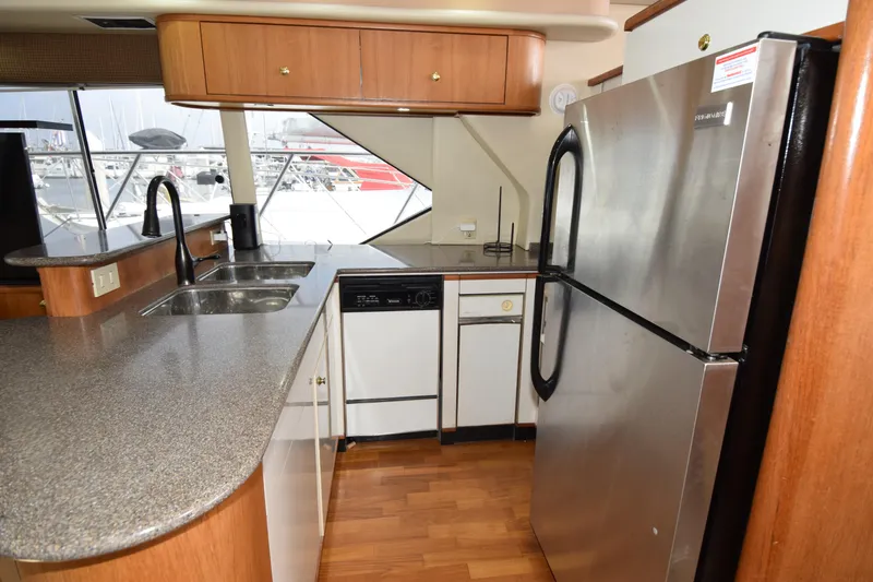 Slide: The Image of Interior of 1999 Bayliner 5288 yacht kitchen with modern appliances and wood flooring. - 7