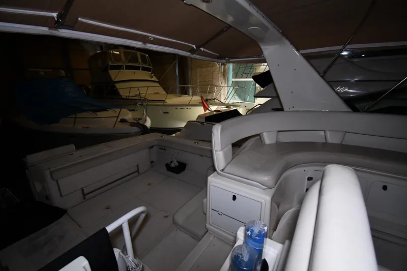 Slide: The Image of 1994 Tiara Yachts 4300 Open interior with seating and storage, docked in a marina. - 16
