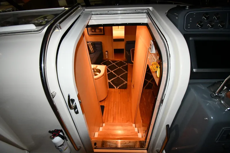 Slide: The Image of 1994 Tiara Yachts 4300 Open interior cabin entrance with wooden flooring and cozy seating. - 20