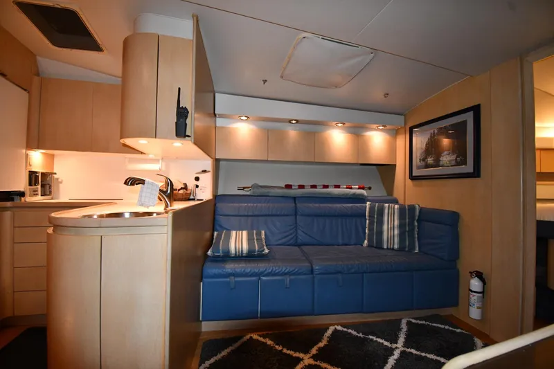 Slide: The Image of 1994 Tiara Yachts 4300 Open interior with blue sofa, kitchenette, and modern decor. - 28