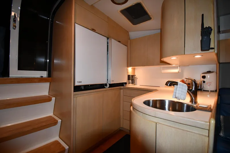 Slide: The Image of 1994 Tiara Yachts 4300 Open kitchen with modern appliances and wooden cabinetry. - 31