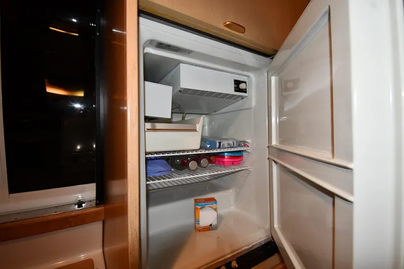 Slide: The Image of Open refrigerator inside 1994 Tiara Yachts 4300 Open, partially stocked with items. - 36