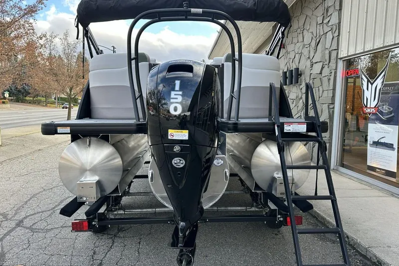 Slide: The Image of 2026 Godfrey Sweetwater 2286 SBC pontoon boat with 150 HP engine, parked outside dealership. - 5