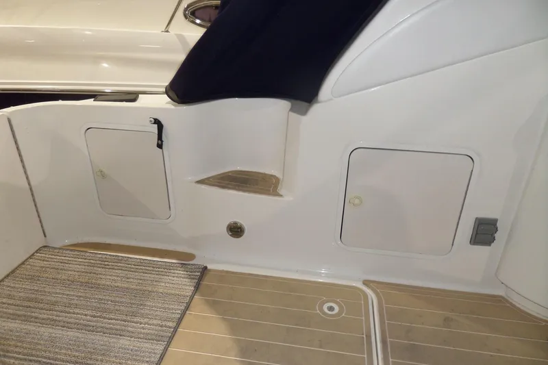 Slide: The Image of 2000 Sea Ray 340 Sundancer boat interior with storage compartments and carpeted flooring. - 16