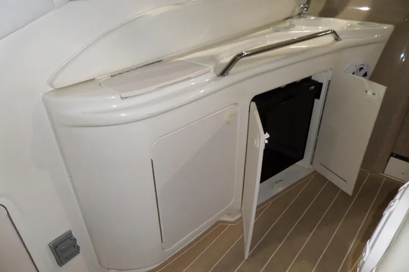 Slide: The Image of 2000 Sea Ray 340 Sundancer interior with open cabinet and sink area. - 20