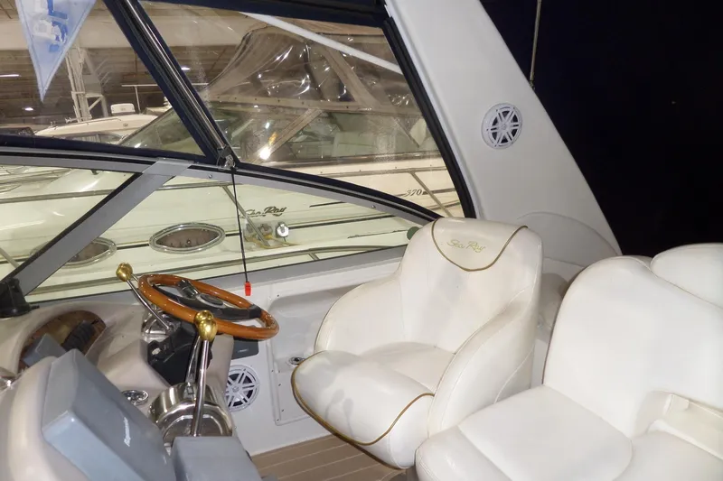 Slide: The Image of Interior of 2000 Sea Ray 340 Sundancer with white seating and wooden steering wheel. - 23