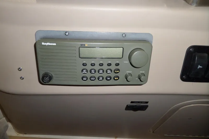 Slide: The Image of Raytheon marine radio on 2000 Sea Ray 340 Sundancer dashboard, featuring control buttons and display. - 27