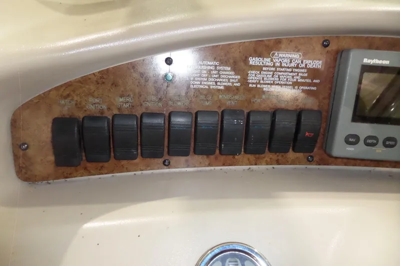 Slide: The Image of Control panel of a 2000 Sea Ray 340 Sundancer boat with switches and warning labels. - 28