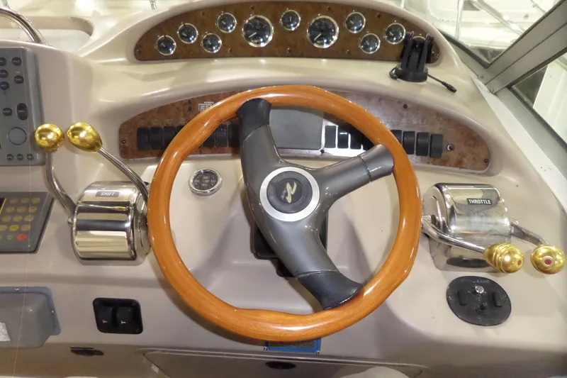 Slide: The Image of Steering wheel and controls of a 2000 Sea Ray 340 Sundancer boat. - 31