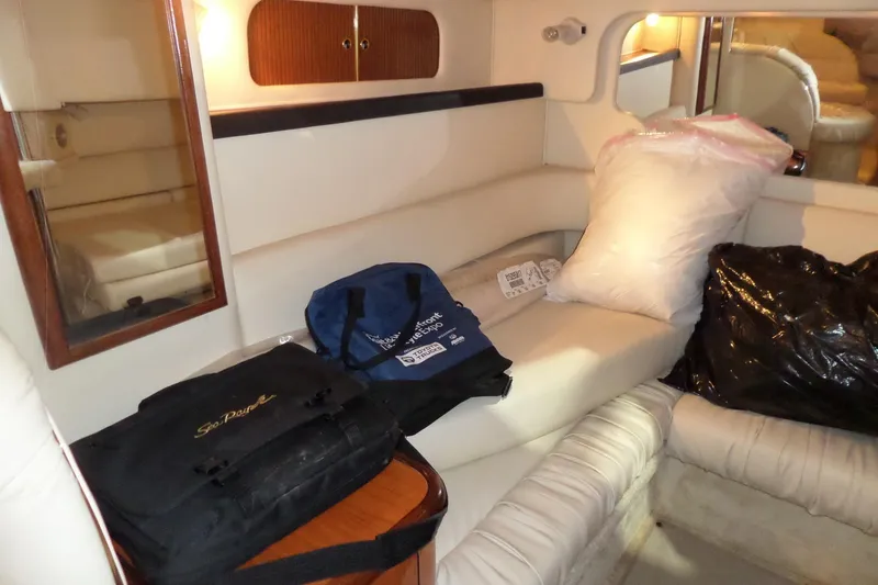 Slide: The Image of Interior of 2000 Sea Ray 340 Sundancer with bags and cushions on seating area. - 37