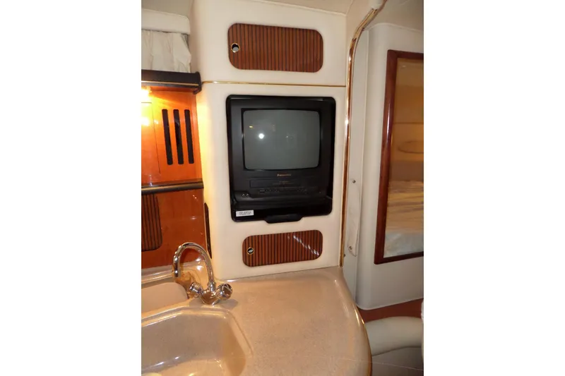 Slide: The Image of 2000 Sea Ray 340 Sundancer interior with TV, sink, and wood accents. - 46