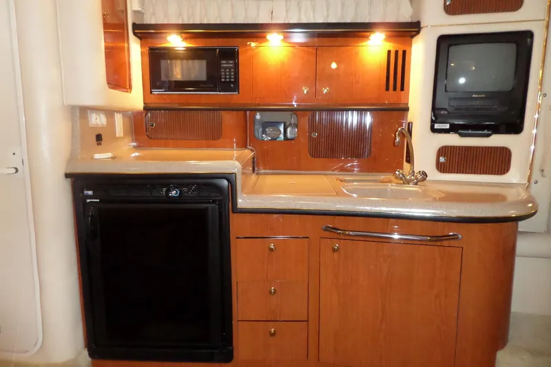 Slide: The Image of Luxurious kitchen interior of 2000 Sea Ray 340 Sundancer yacht with wood cabinetry and modern appliances. - 50