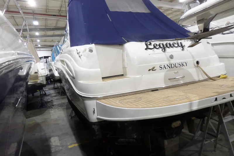Slide: The Image of 2000 Sea Ray 340 Sundancer boat in storage, featuring "Legacy" and "Sandusky" on the stern. - 6