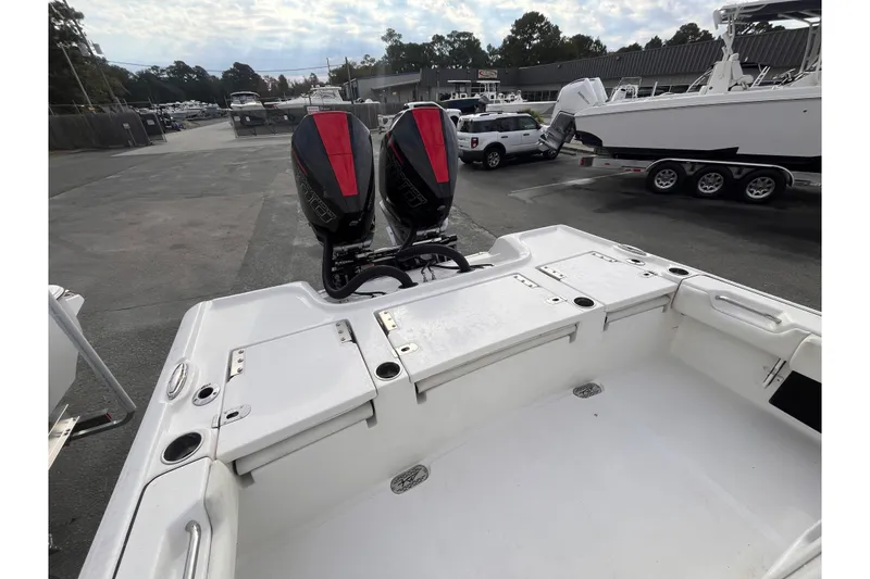 Slide: The Image of 2023 Tidewater 2700 Carolina Bay boat with dual outboard motors in a marina setting. - 4