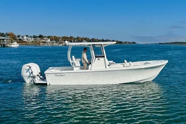 Slide: The Image of 2026 Pair Customs 24 Center Console DV boat on calm water, clear blue sky. - 2