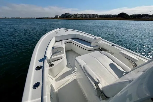 Slide: The Image of 2026 Pair Customs 24 Center Console DV boat on calm water, featuring sleek white seating. - 6