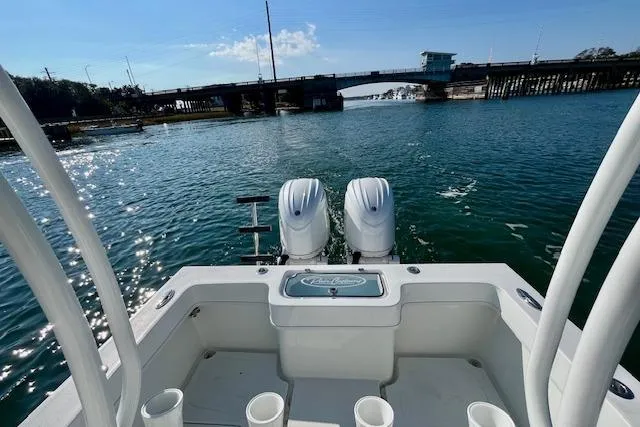 Slide: The Image of 2026 Pair Customs 24 Center Console DV boat on water near a bridge. - 8