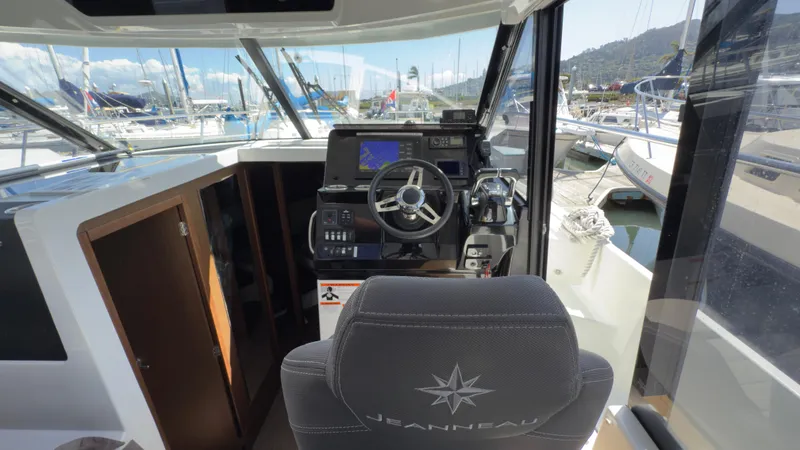 Slide: The Image of 2019 Jeanneau NC Weekender 1095 helm with navigation equipment and marina view. - 10