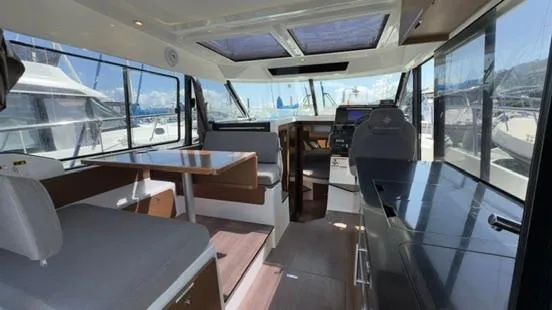 Slide: The Image of 2019 Jeanneau NC Weekender 1095 interior with seating, table, and helm station. - 12