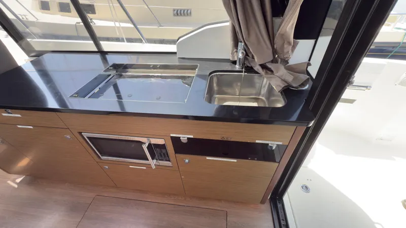Slide: The Image of 2019 Jeanneau NC Weekender 1095 interior kitchen with sink and microwave. - 13
