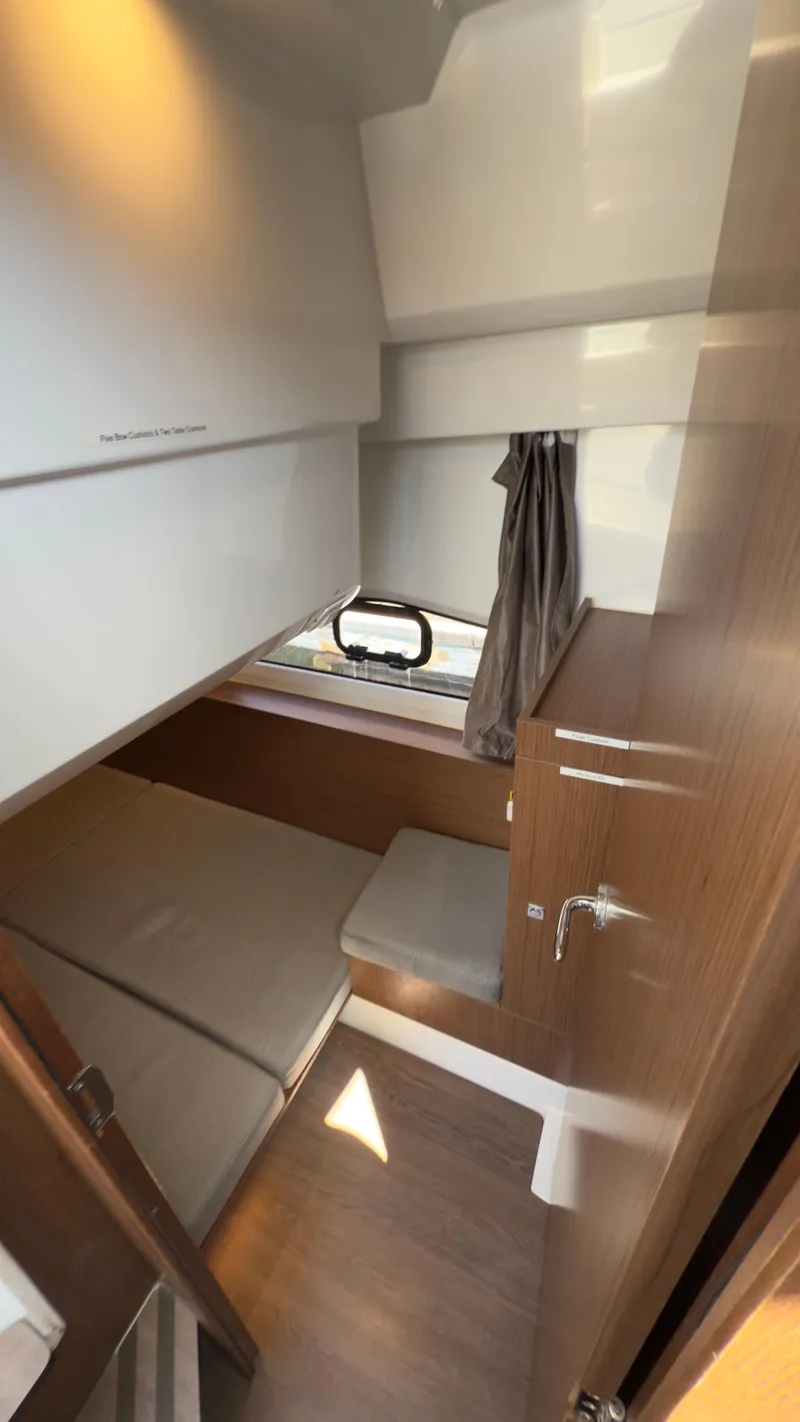 Slide: The Image of 2019 Jeanneau NC Weekender 1095 cabin interior with bed, window, and wooden accents. - 16