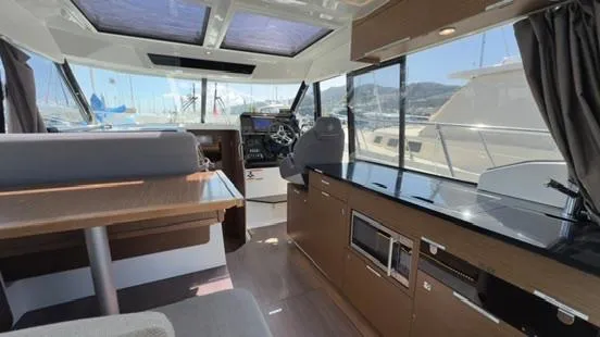 Slide: The Image of Interior of 2019 Jeanneau NC Weekender 1095, featuring modern helm and galley area. - 19