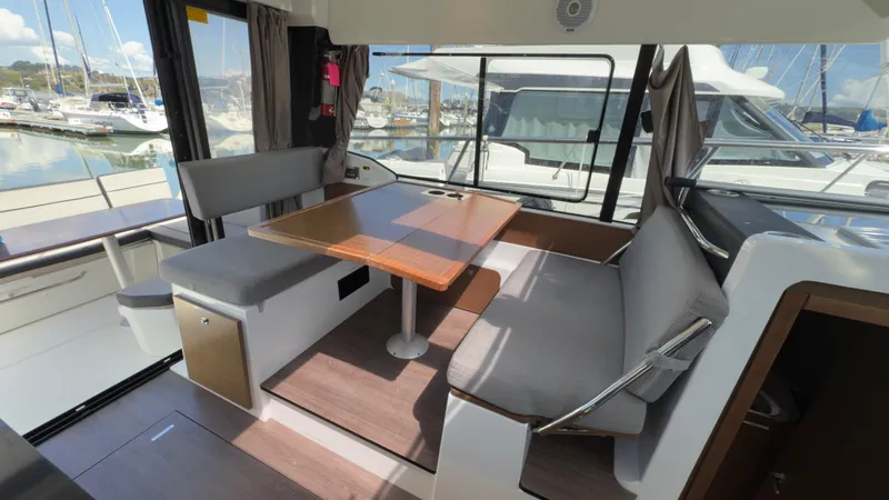 Slide: The Image of Interior of 2019 Jeanneau NC Weekender 1095, featuring a cozy dining area with marina view. - 20
