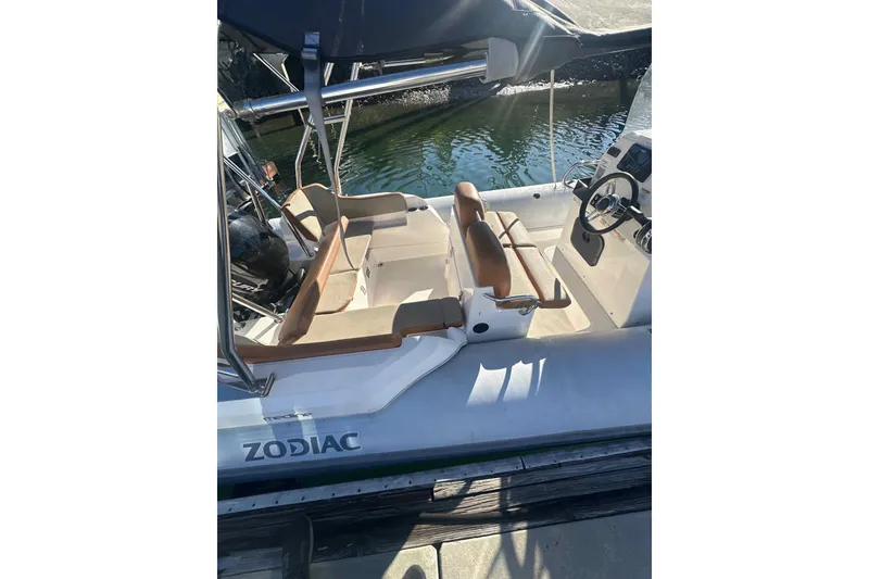 Slide: The Image of 2022 Zodiac Medline 6.8 boat docked by palm trees and waterfront building. - 1